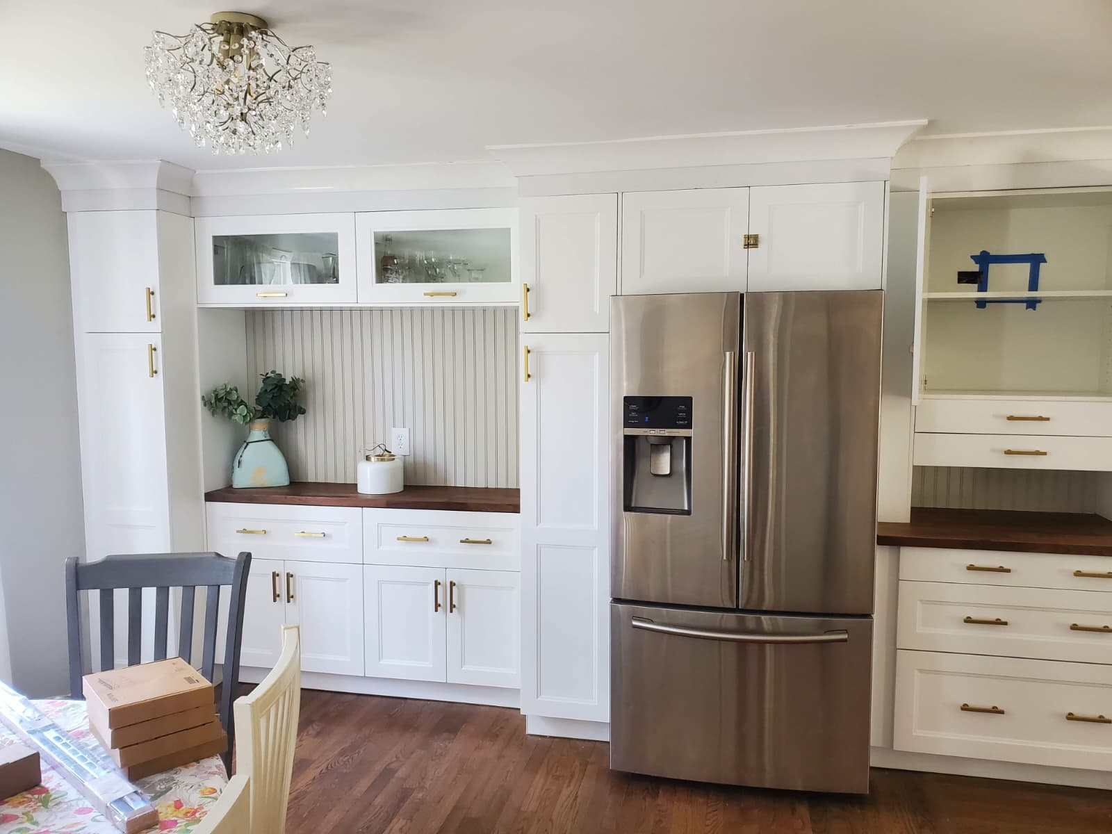 White kitchen pantry wall with glass uppers and walnut counters