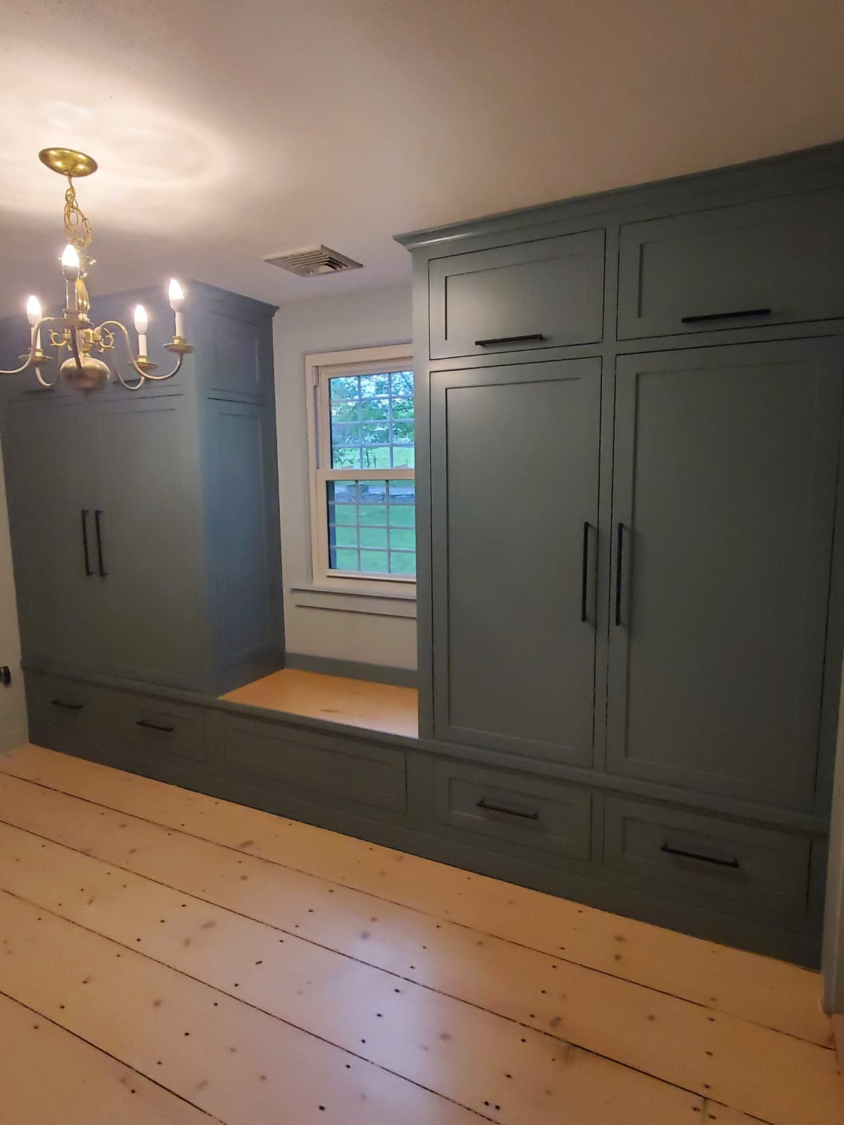 Floor-to-ceiling painted wardrobes with a built-in window bench
