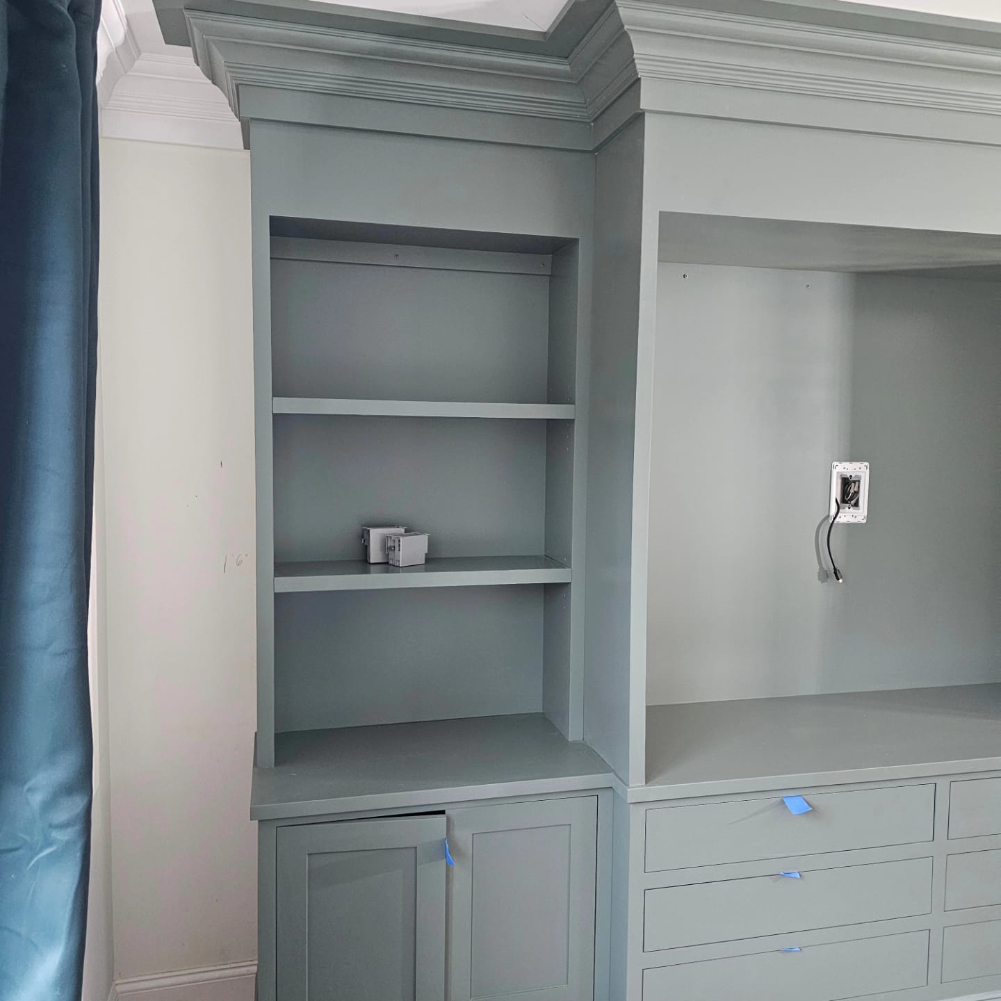 Gray built-in bookcase and media cabinet with crown molding
